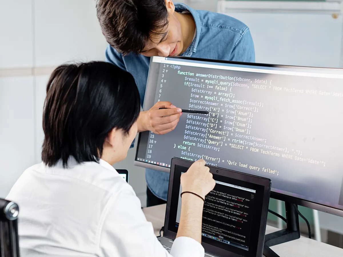 Two engineers reviewing a build on a monitor