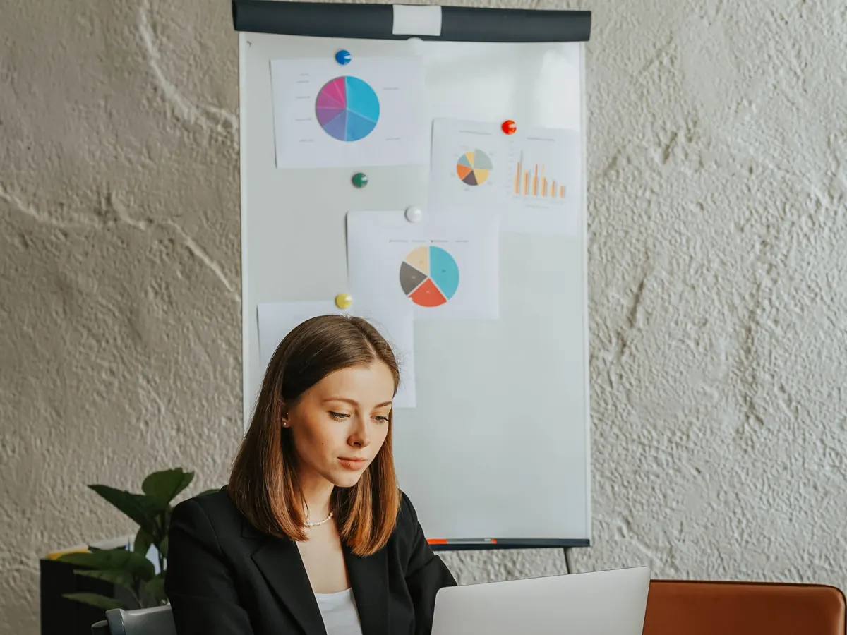 An analyst comparing results on a laptop against charts on a flip chart