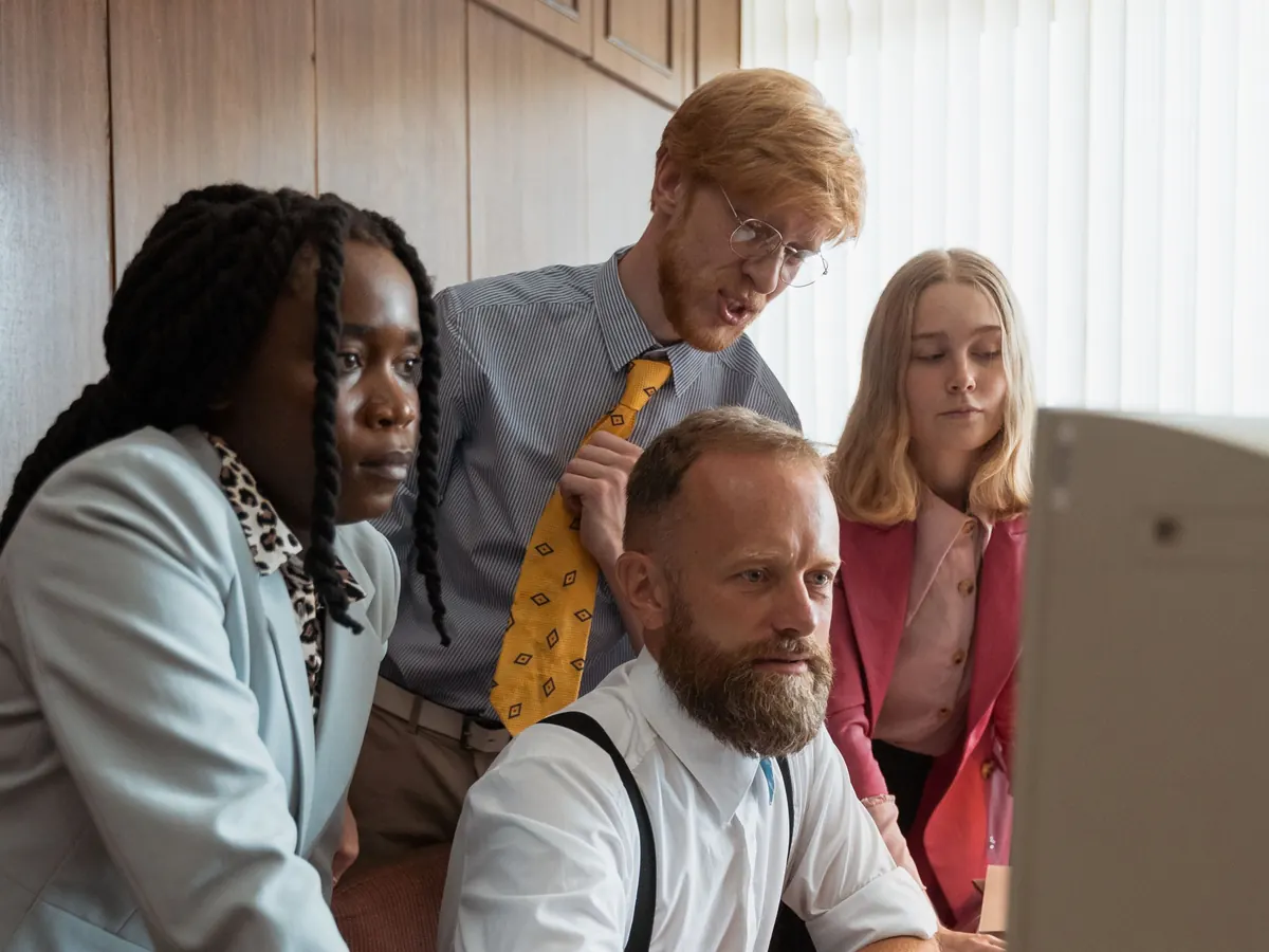 A team gathered around one monitor reviewing results