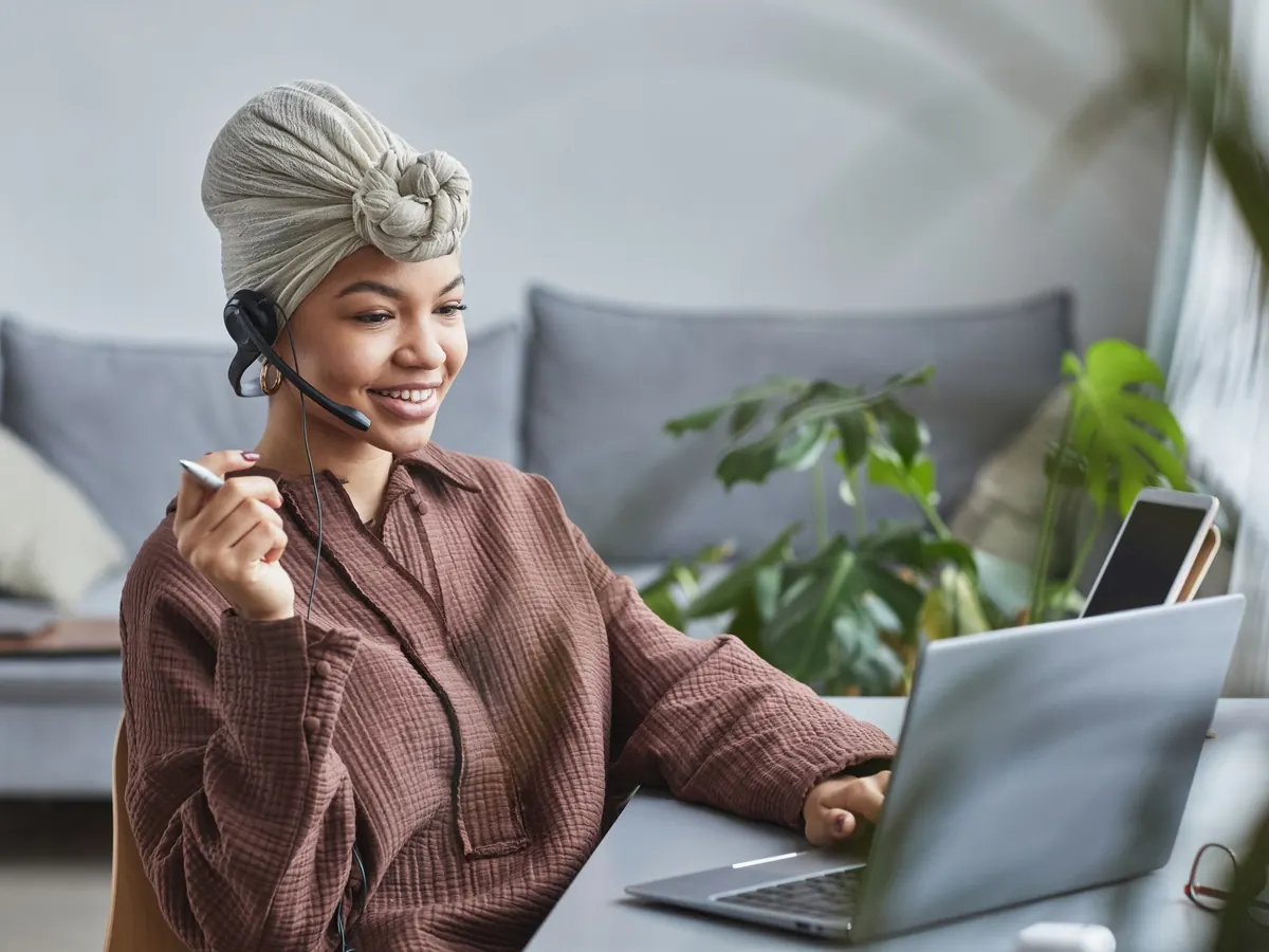 A developer smiling on a call at her laptop