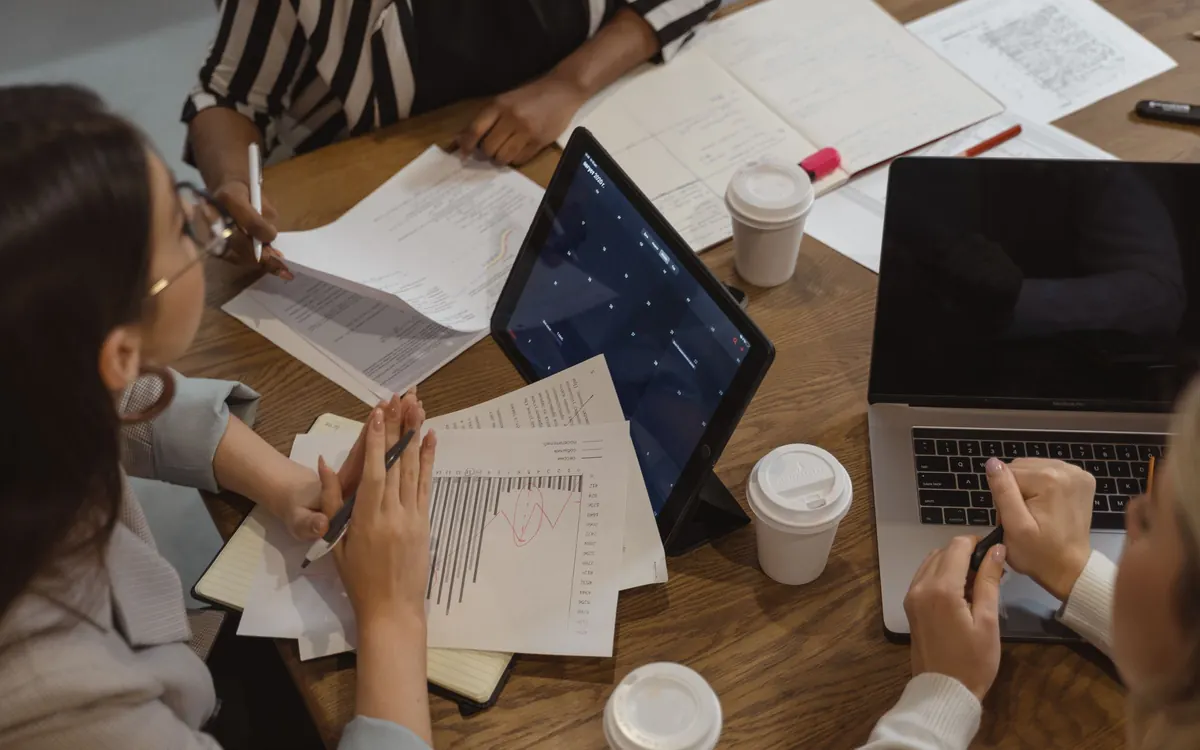 A team working through documents and laptops at one table